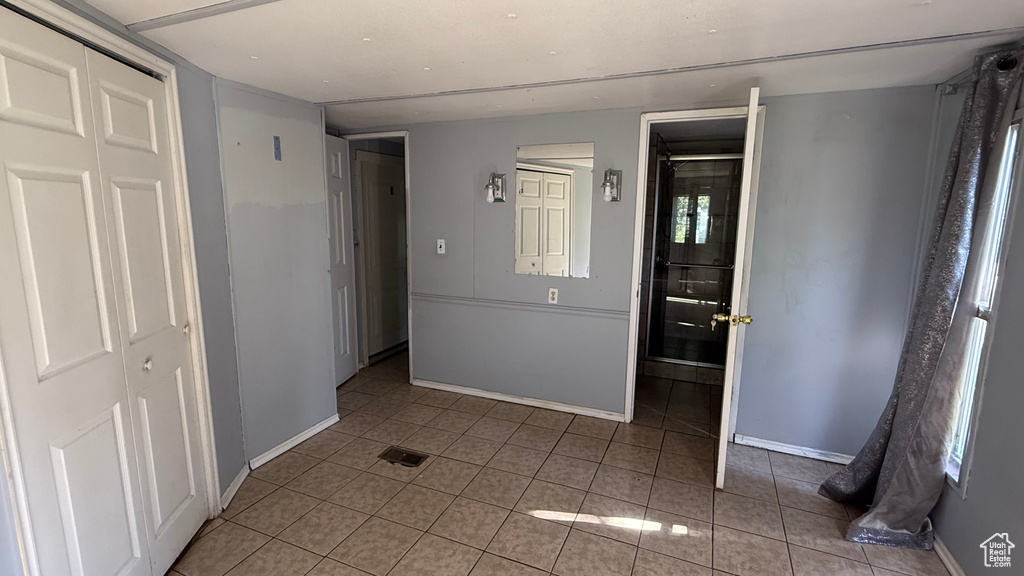 Unfurnished bedroom with tile patterned flooring and a closet