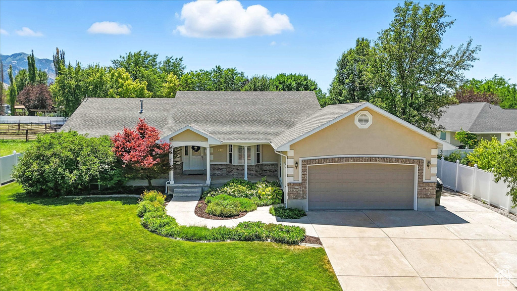 View of front of home featuring covered porch, a garage, driveway, and stucco siding