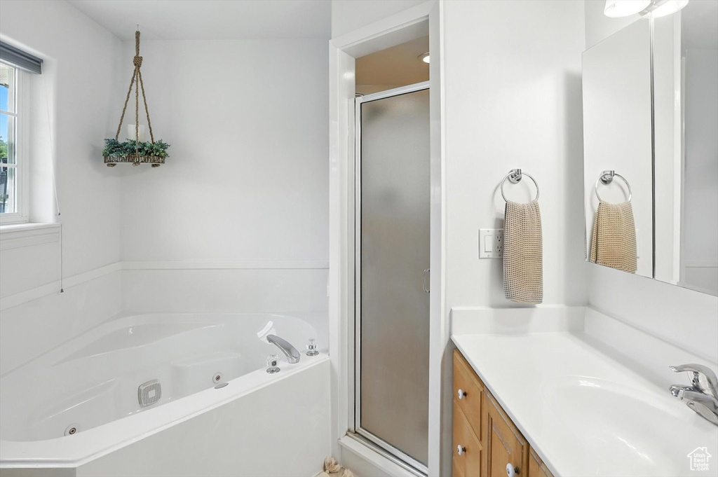 Full bath featuring a stall shower, vanity, and a jetted tub