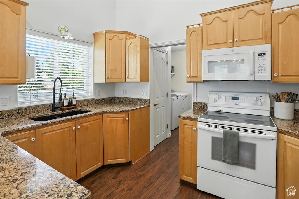 Kitchen with white appliances, dark wood-type flooring, independent washer and dryer, stone countertops, and light brown cabinetry