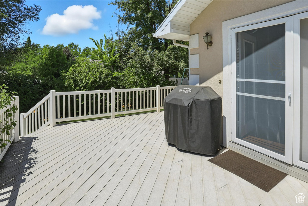 Deck featuring grilling area and view of scattered trees