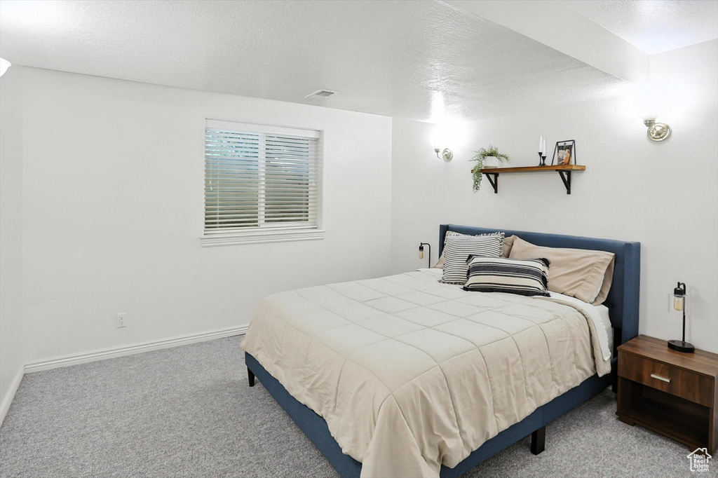Bedroom featuring carpet floors and a textured ceiling