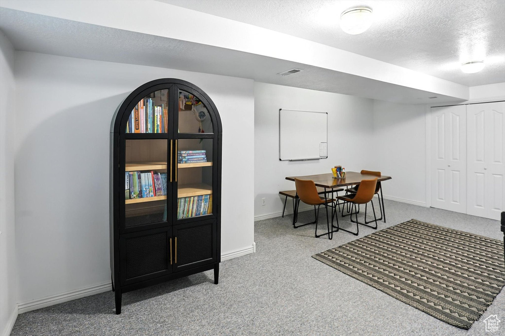 Dining room featuring carpet and a textured ceiling