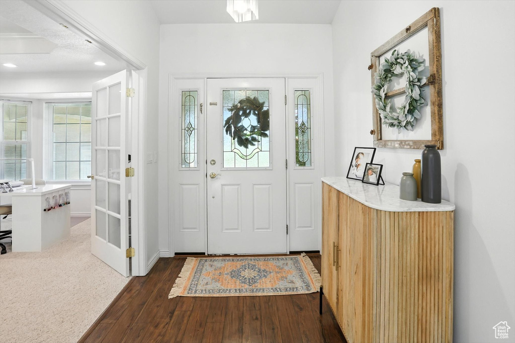 Foyer entrance with dark wood-style flooring and recessed lighting