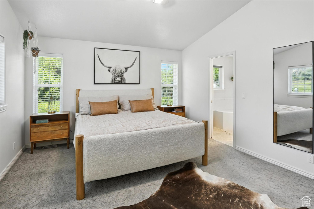 Bedroom with carpet, vaulted ceiling, and ensuite bathroom