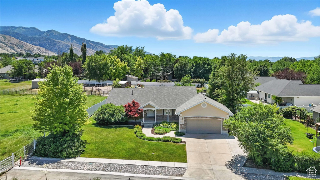 View of front facade with concrete driveway, an attached garage, and a mountain view