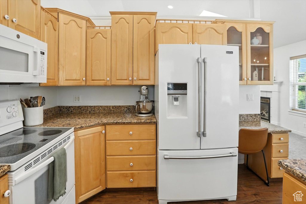 Kitchen featuring white appliances, dark wood-type flooring, glass insert cabinets, and light brown cabinetry