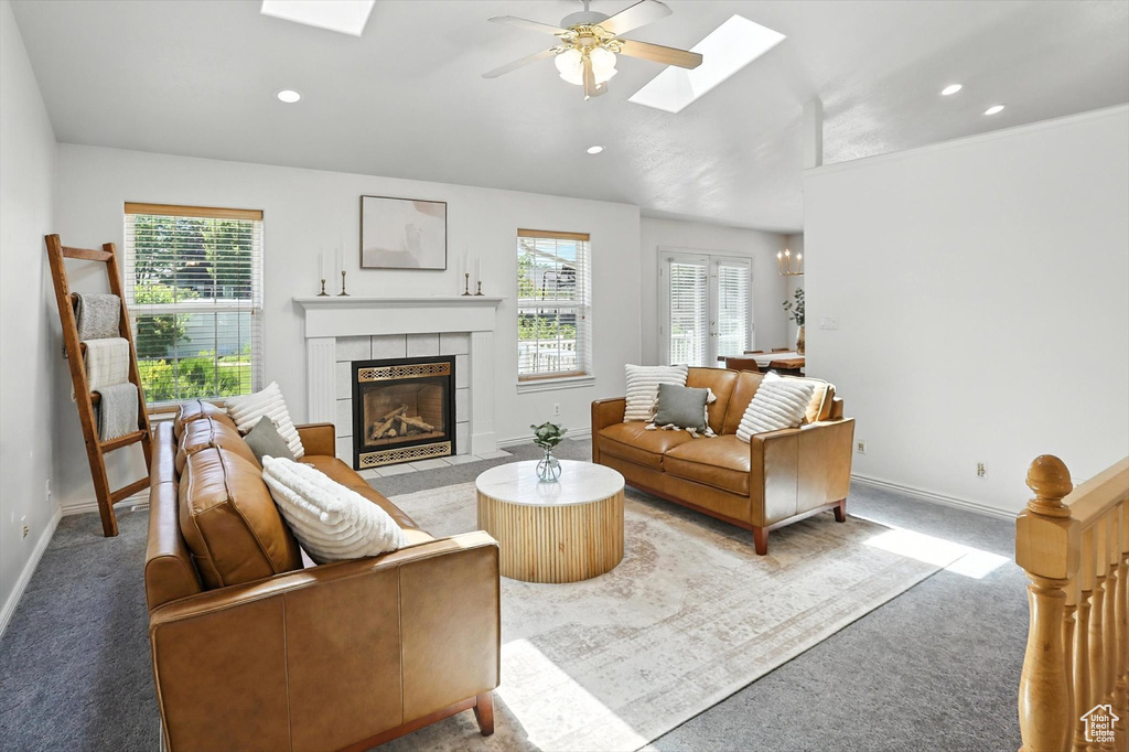 Carpeted living area with a skylight, a fireplace, a ceiling fan, and recessed lighting