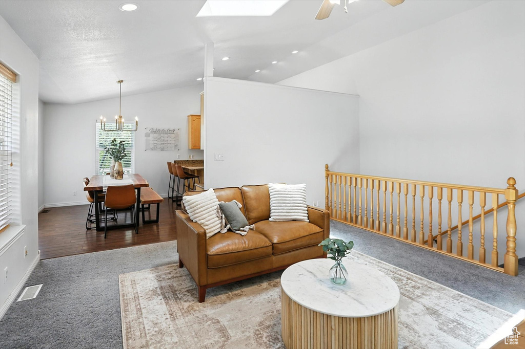 Living room with vaulted ceiling, a chandelier, light carpet, a ceiling fan, and recessed lighting