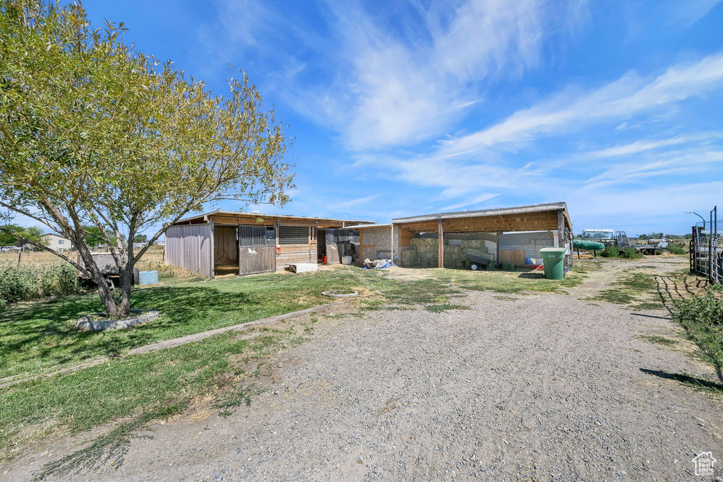 View of front of property featuring an outdoor structure, driveway, an outbuilding, and a carport