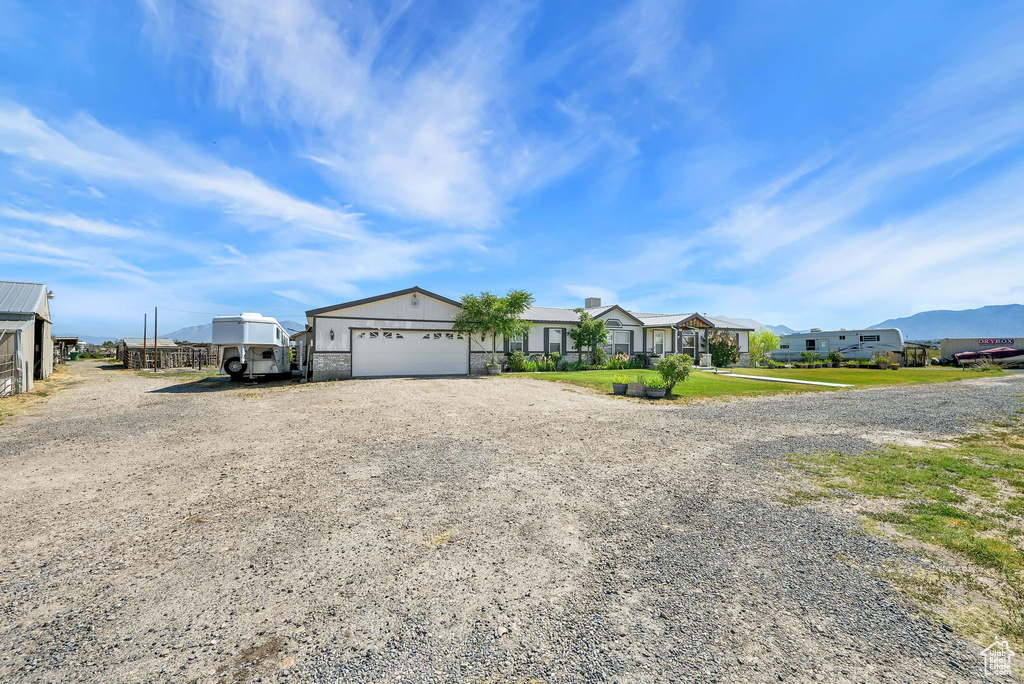 Single story home featuring gravel driveway, a residential view, and a garage