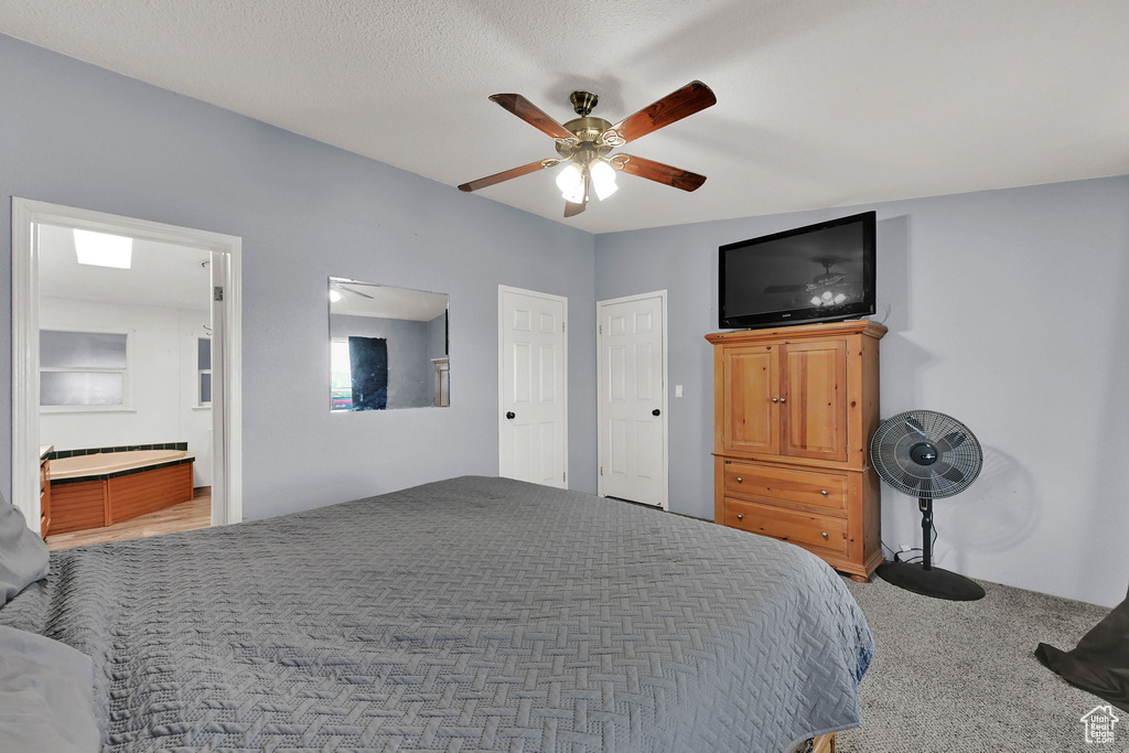 Bedroom featuring a ceiling fan, carpet floors, and ensuite bathroom
