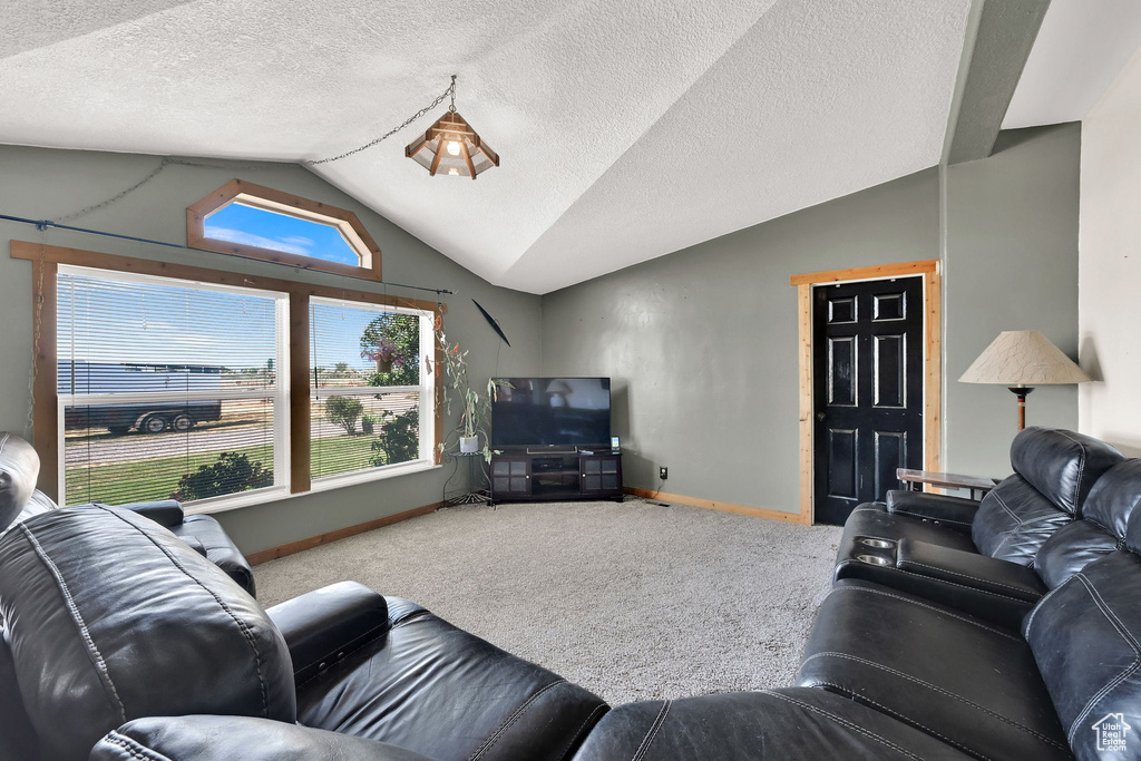 Carpeted living room featuring lofted ceiling and baseboards