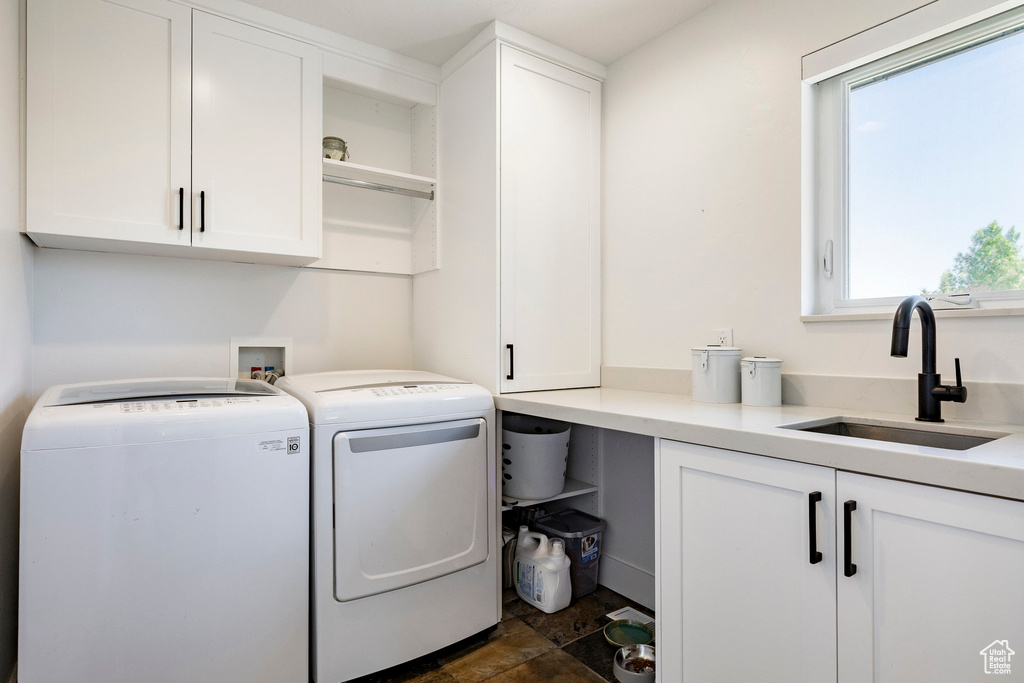Laundry room featuring cabinet space, independent washer and dryer, and dark stone finish flooring