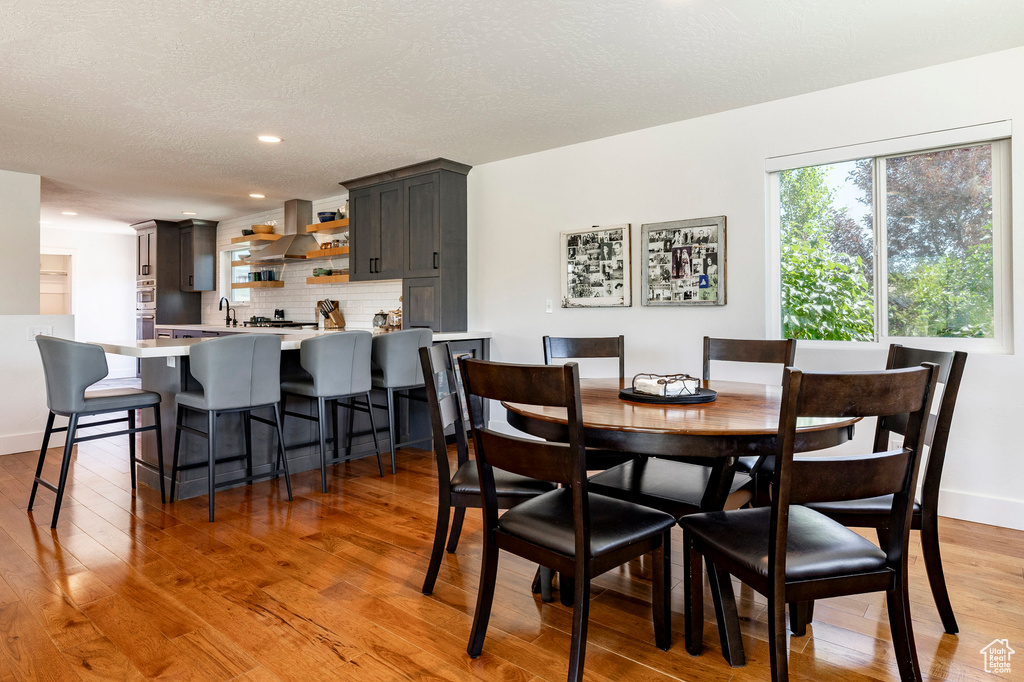 Dining room with light wood-type flooring and recessed lighting
