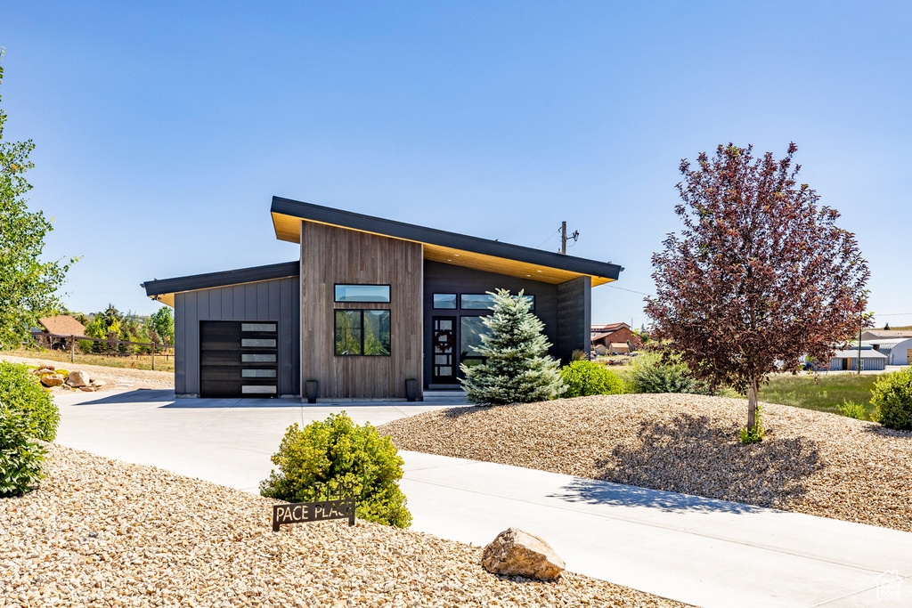 Contemporary home featuring concrete driveway and a garage