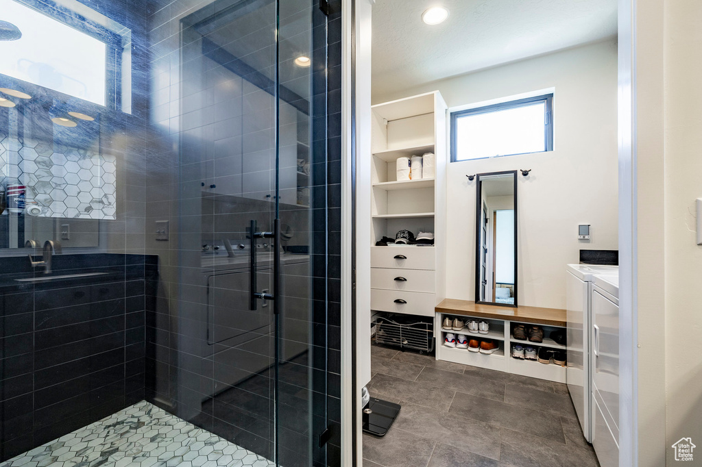 Bathroom featuring washing machine and clothes dryer, a shower stall, vanity, and recessed lighting