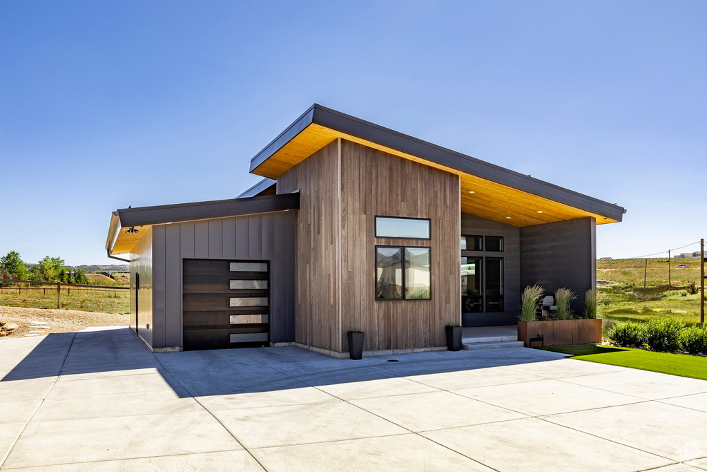 View of outbuilding featuring driveway and a garage