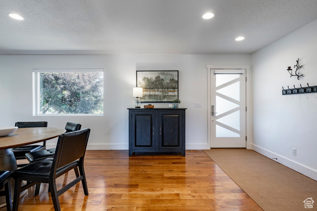 Dining area with healthy amount of natural light, recessed lighting, and light wood-style floors