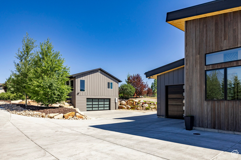 View of side of home with driveway and an attached garage