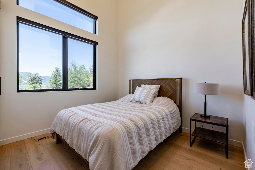 Bedroom featuring multiple windows and light wood-style floors