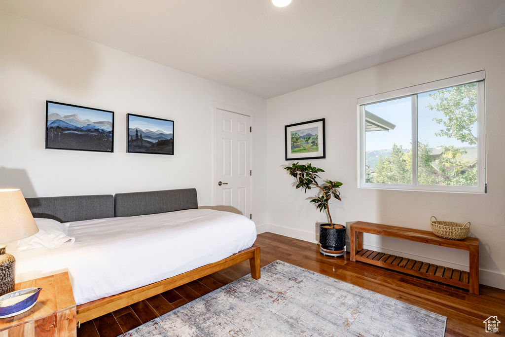 Bedroom with wood finished floors and baseboards
