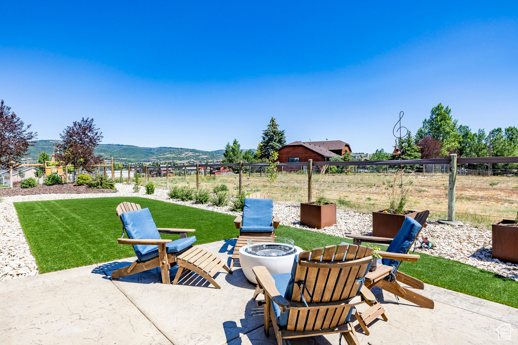 View of patio with a fire pit and a mountain view