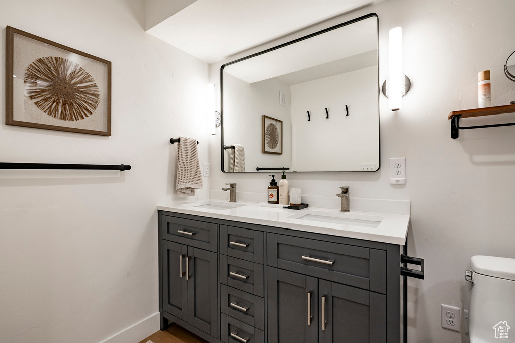 Full bathroom featuring double vanity and toilet