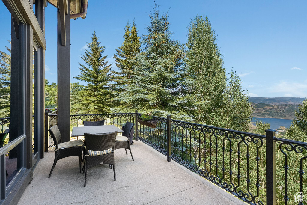 Balcony with outdoor dining space and a water view