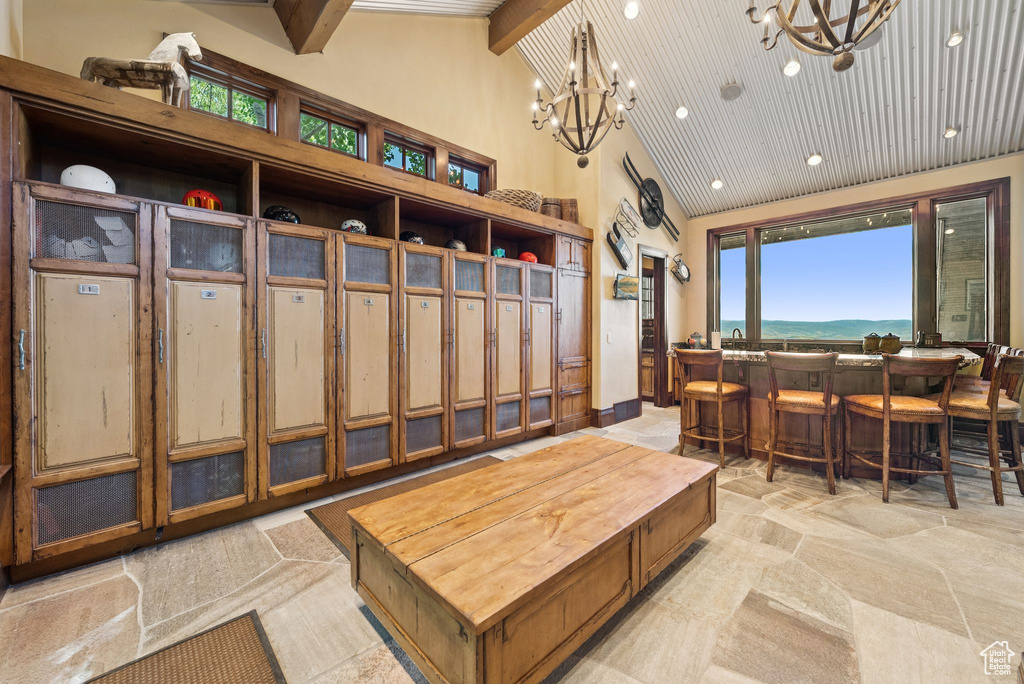 Mudroom featuring high vaulted ceiling, a chandelier, light stone finish flooring, a community bar, and recessed lighting