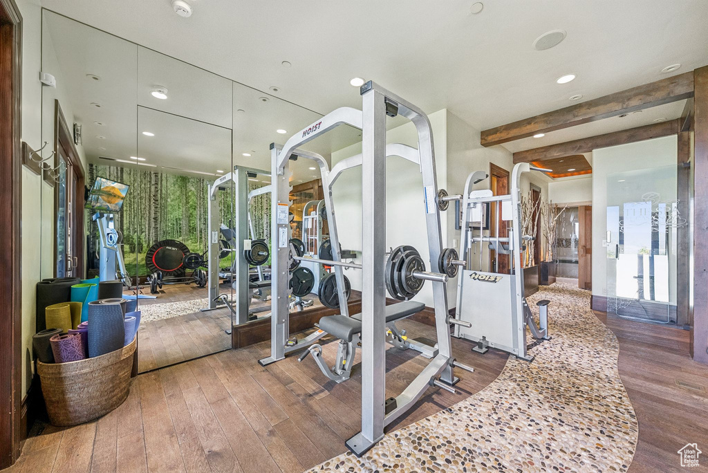 Exercise room with wood-type flooring and recessed lighting