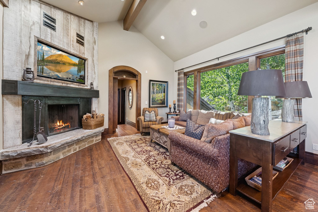 Living area with beam ceiling, wood finished floors, high vaulted ceiling, a fireplace, and recessed lighting