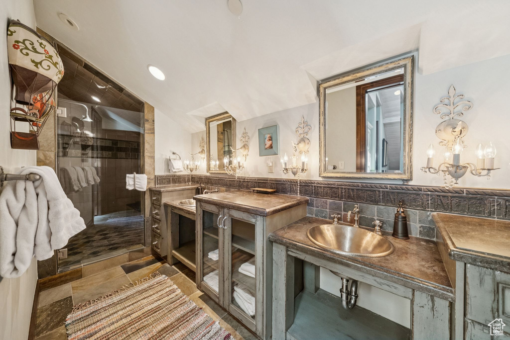 Full bathroom featuring a shower stall, tile walls, and vanity
