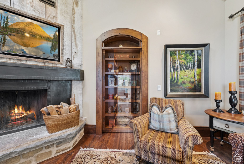 Living area with wood finished floors and a lit fireplace