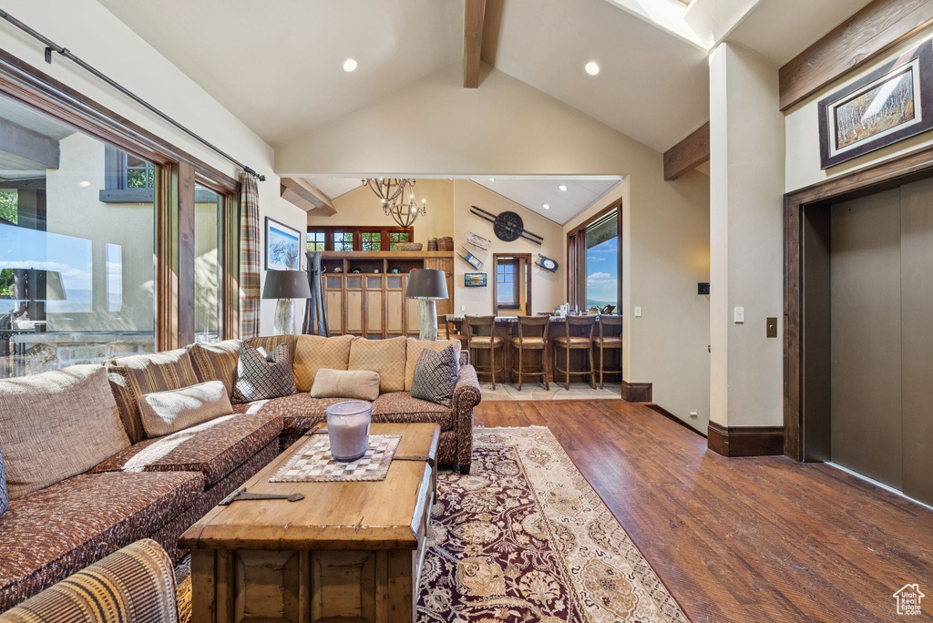 Living room featuring a chandelier, wood finished floors, beam ceiling, recessed lighting, and high vaulted ceiling