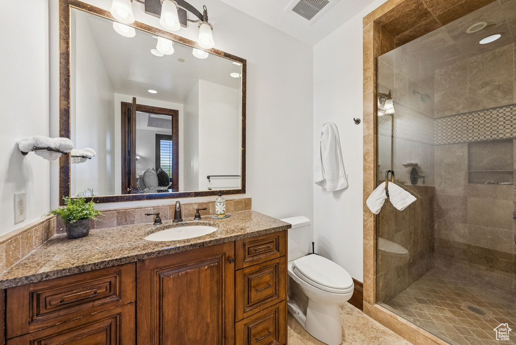Bathroom featuring a tile shower and vanity