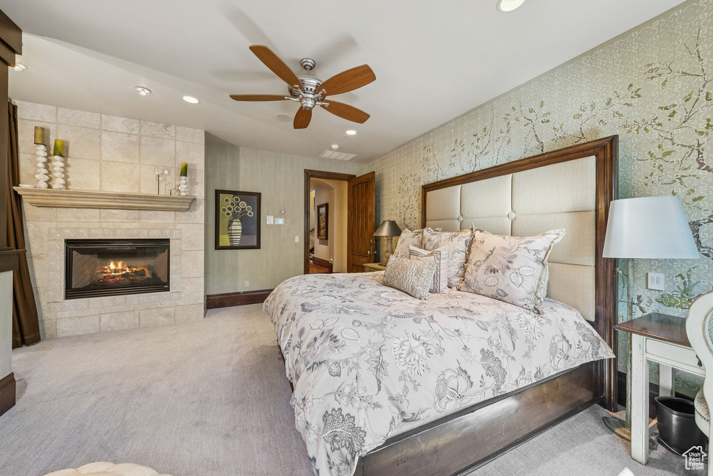 Carpeted bedroom featuring recessed lighting, wallpapered walls, a tile fireplace, and ceiling fan
