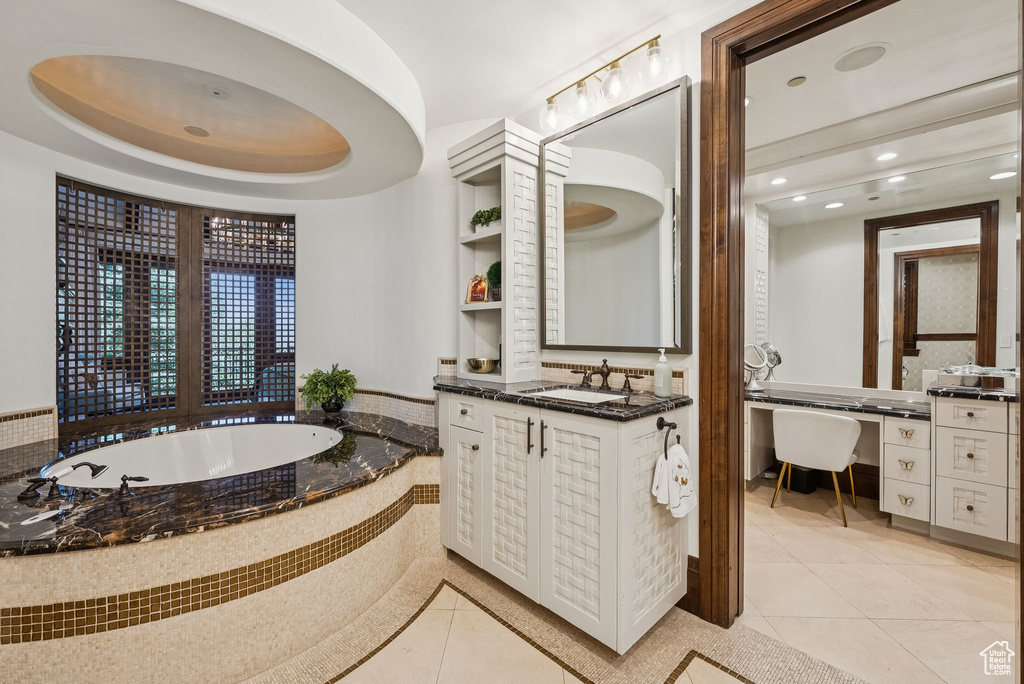 Full bathroom with a freestanding tub, vanity, tile patterned flooring, and recessed lighting