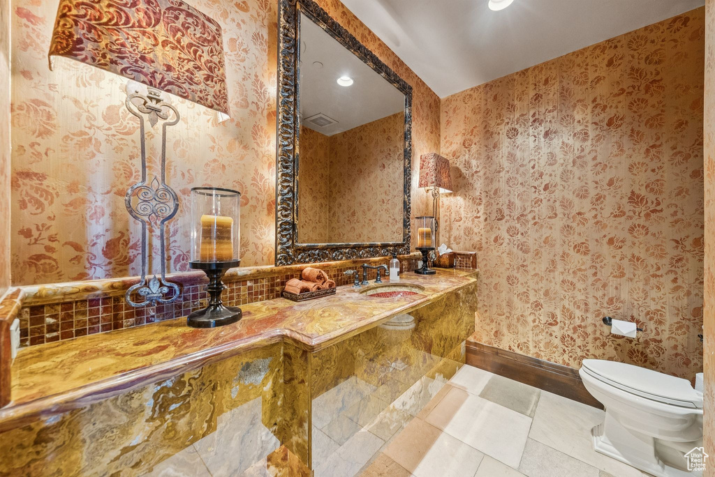 Bathroom with recessed lighting, wallpapered walls, backsplash, and vanity