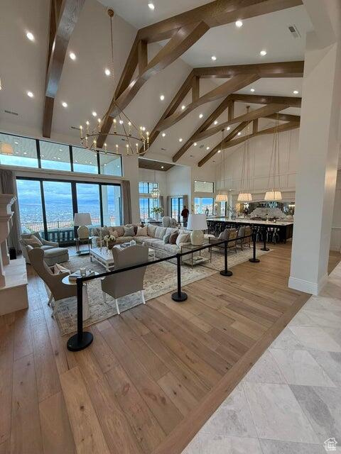 Living room with high vaulted ceiling, beamed ceiling, recessed lighting, and a chandelier