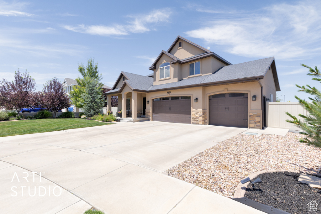 Craftsman house featuring stucco siding, driveway, stone siding, a shingled roof, and an attached garage