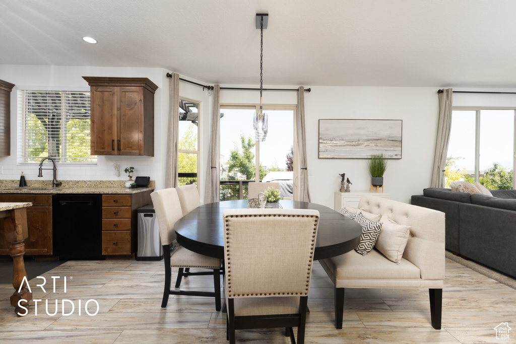 Dining room with light wood finished floors and recessed lighting