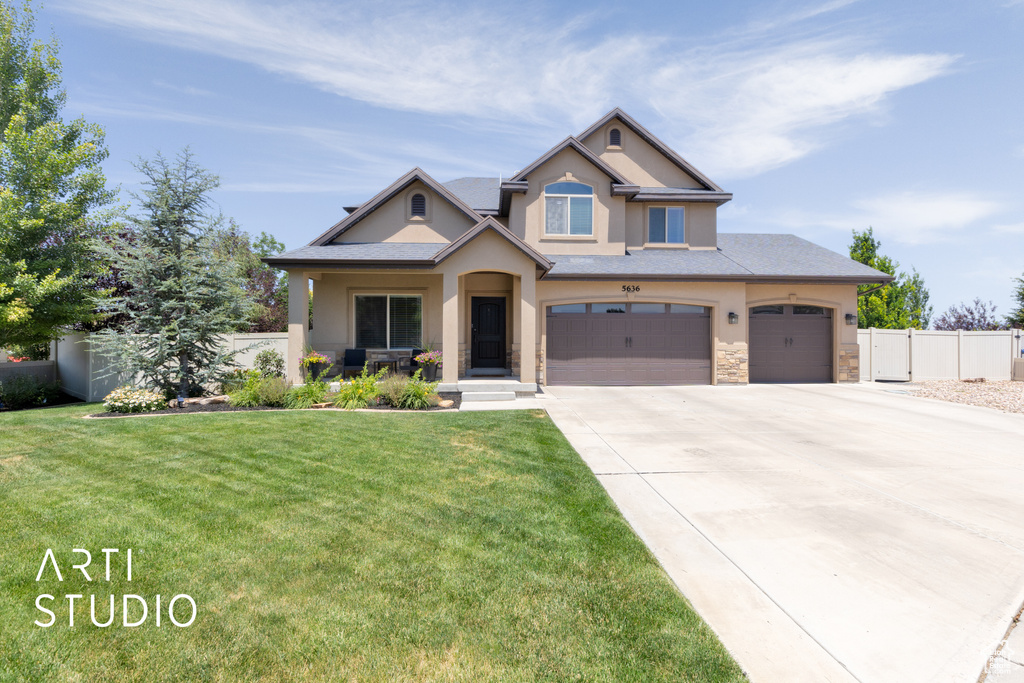 View of front of house with stucco siding, stone siding, concrete driveway, and a garage