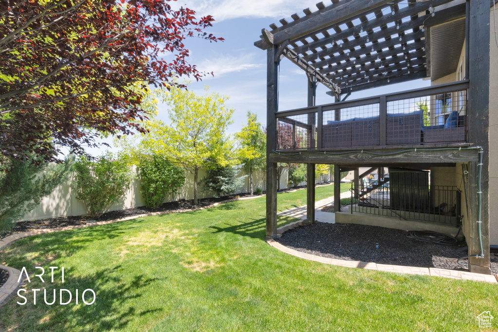 Fenced backyard with a pergola, stairway, and a wooden deck