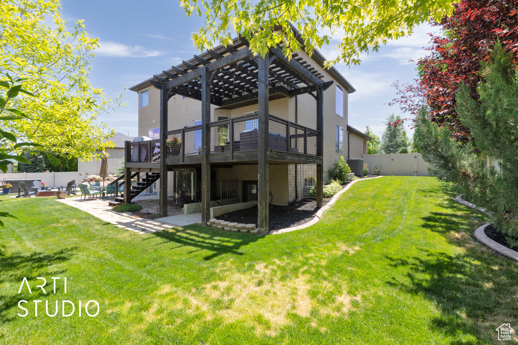 Rear view of house with a pergola, a fenced backyard, a wooden deck, a patio area, and stairway