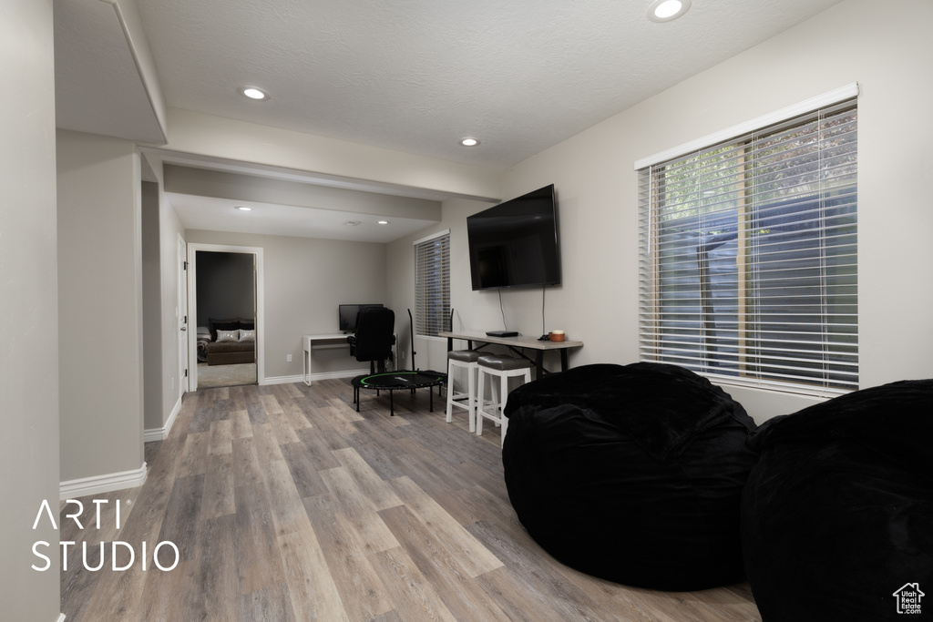 Living room featuring light wood-style floors, recessed lighting, and an office area