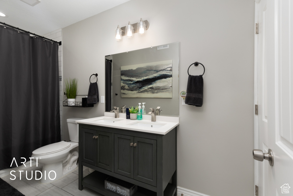 Full bath with double vanity, tile patterned floors, and a shower with shower curtain