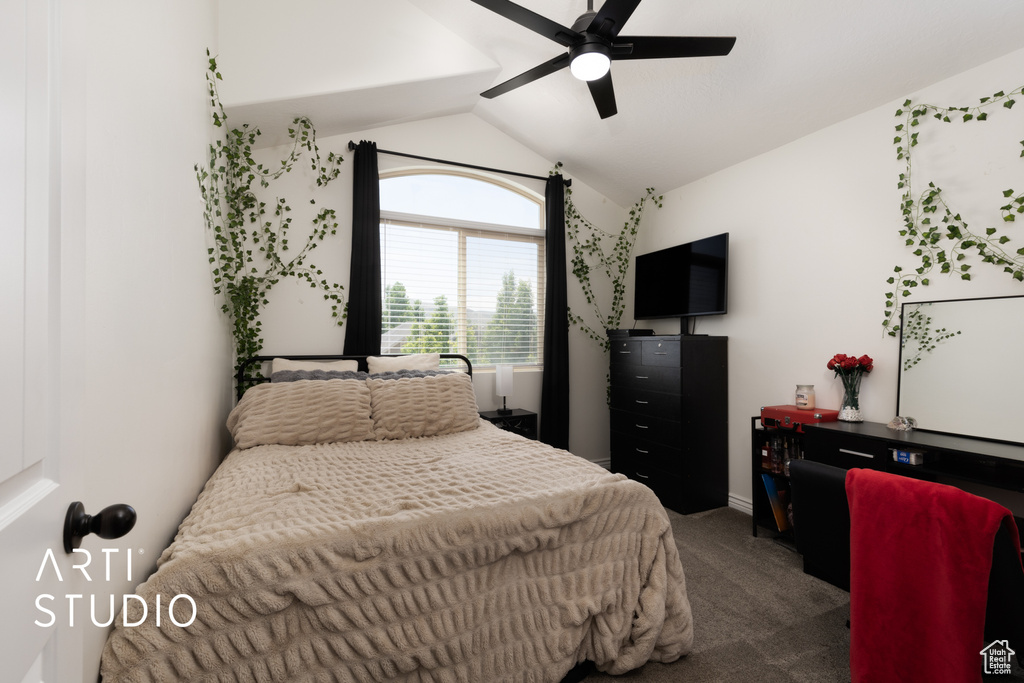 Carpeted bedroom featuring vaulted ceiling and ceiling fan