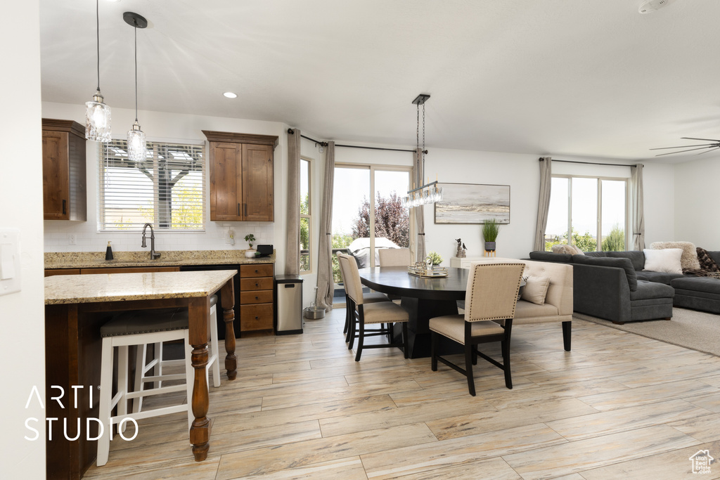 Dining room featuring light wood finished floors, plenty of natural light, recessed lighting, and ceiling fan