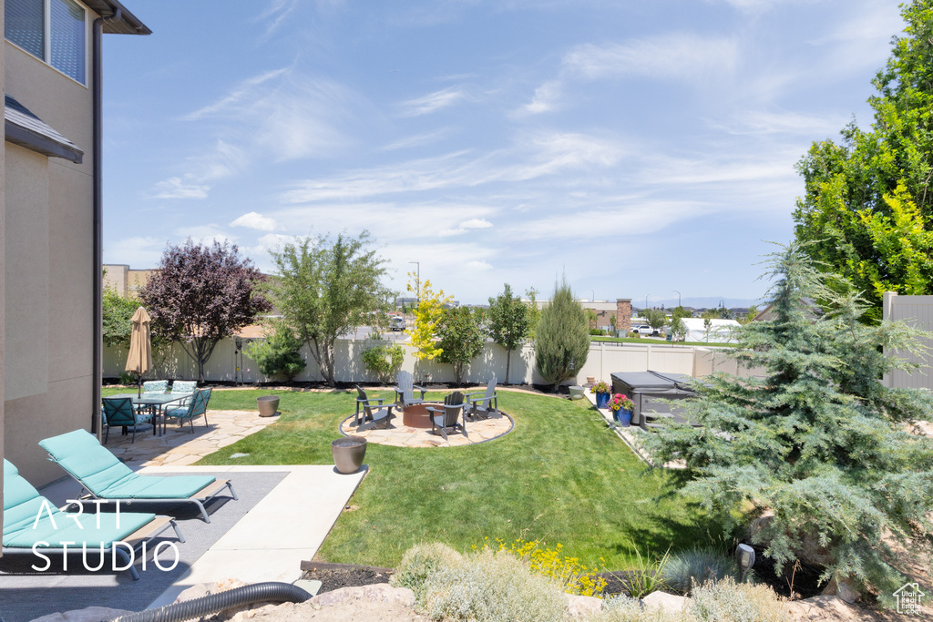 Fenced backyard with a fire pit and a patio area